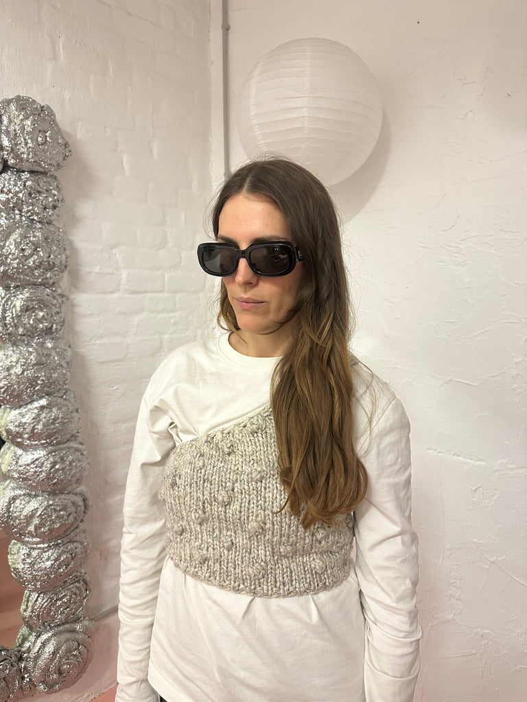 Vintage Longchamp sunglasses in glossy black with a rectangular frame and dark lenses, laid flat on a light surface.