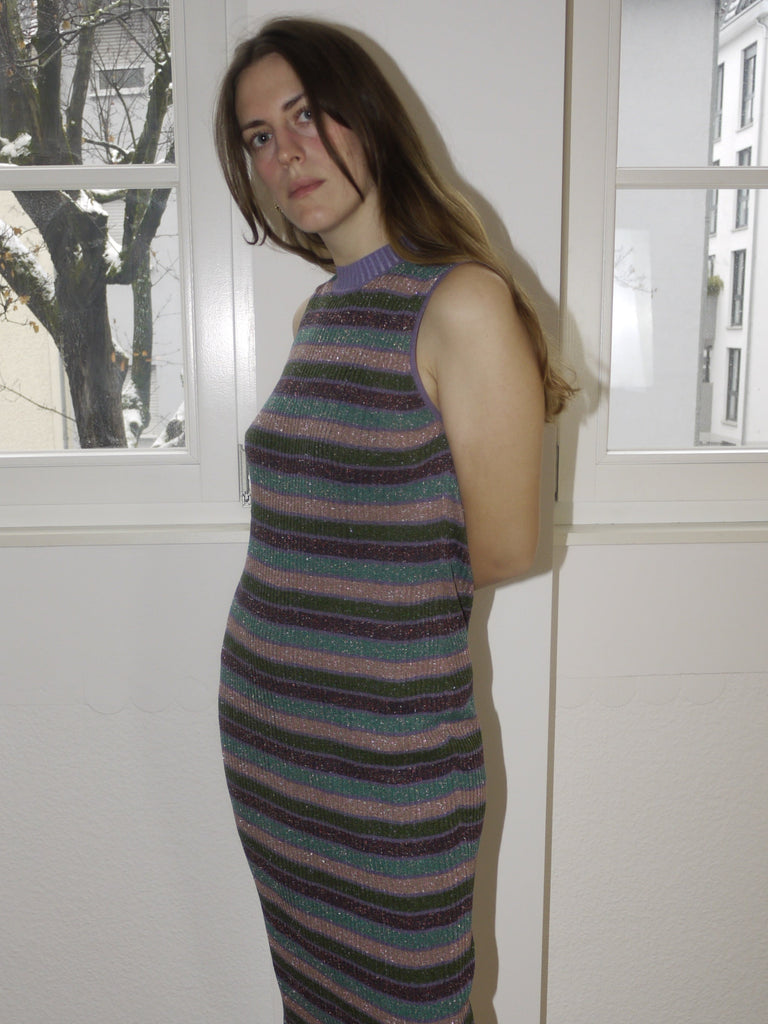 Original Alexander McQueen sleeveless midi dress with horizontal navy and beige stripe pattern, form-fitting silhouette with high neckline, styled with red suede heels, modeled indoors.