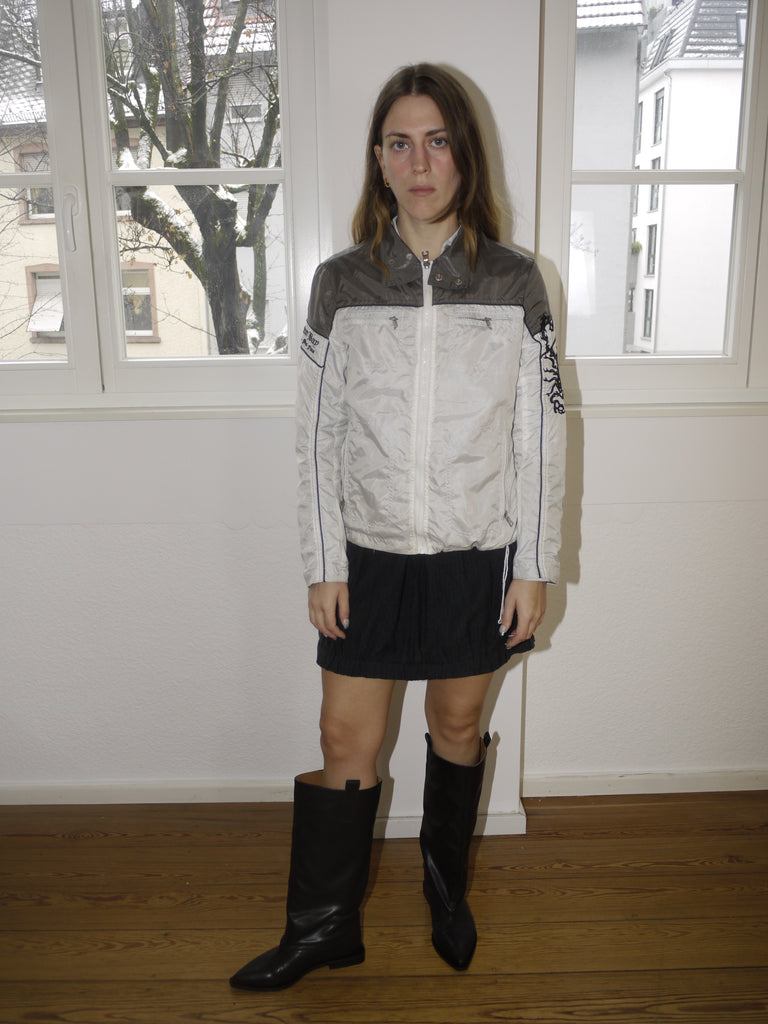Original Ganni black leather knee-high boots with round toe and flat sole, timeless Scandinavian design, styled with mini skirt and layered look, perfect for transitional seasons.