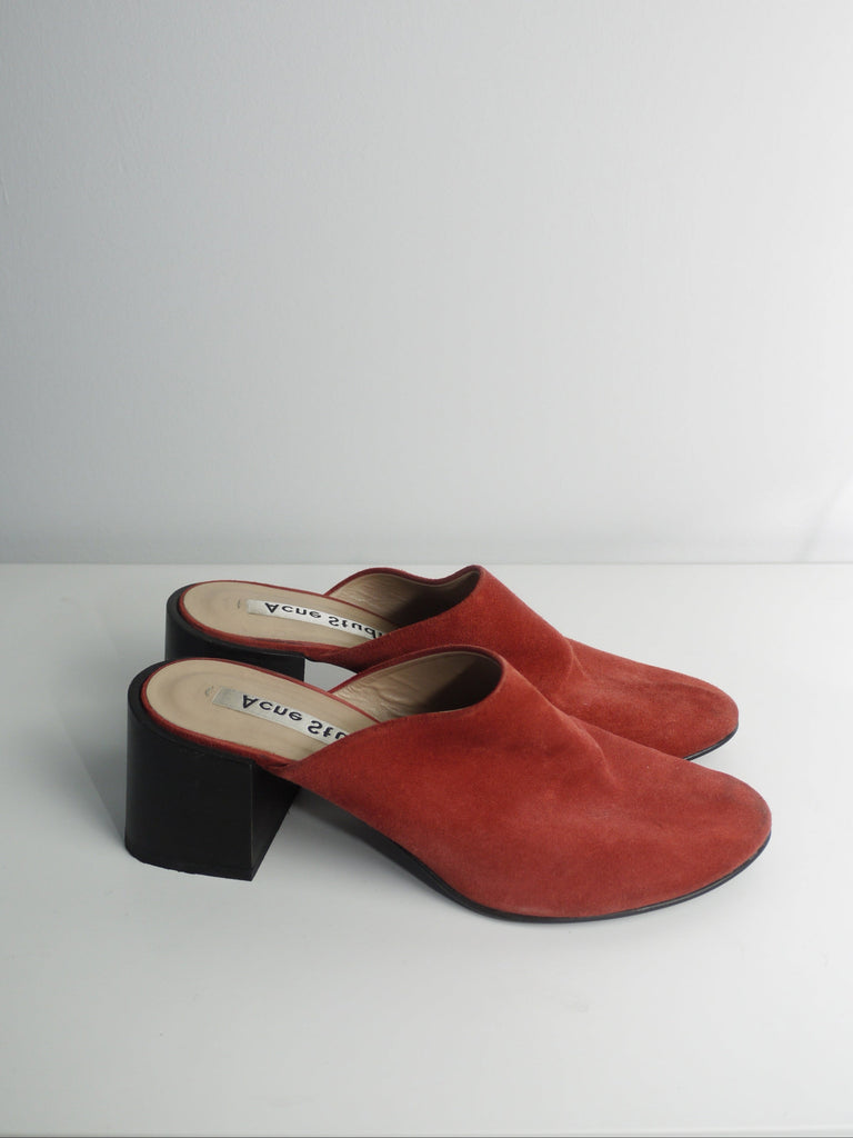 Original Acne Studios red suede mules with rounded toe and chunky block heel, modern minimalist design with Scandinavian flair, photographed on white background.