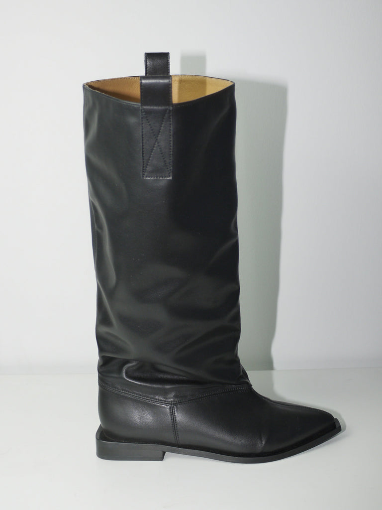 Original Ganni black leather knee-high boots with round toe and flat sole, timeless Scandinavian design, styled with mini skirt and layered look, perfect for transitional seasons.