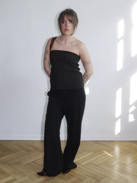 Brown strapless wool top with subtle ribbed texture, fitted silhouette, styled with black trousers. Minimal and sleek layering piece for spring.