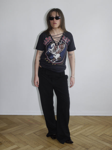 Fitted black graphic tee with bold eagle and skull print, styled with low-rise black pants – edgy Y2K streetwear look.