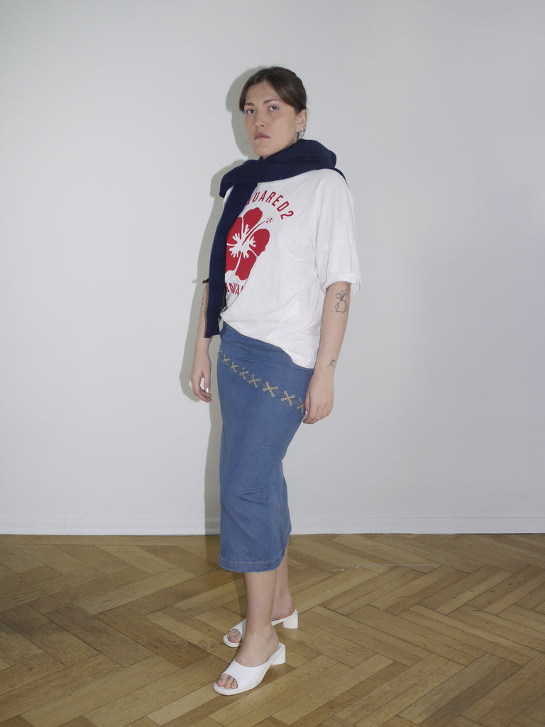 White Dsquared² t-shirt with bold red maple leaf and “Hawaii” print on the front. Paired with a vintage low-rise denim midi skirt and a navy sweater casually draped over the shoulders.
