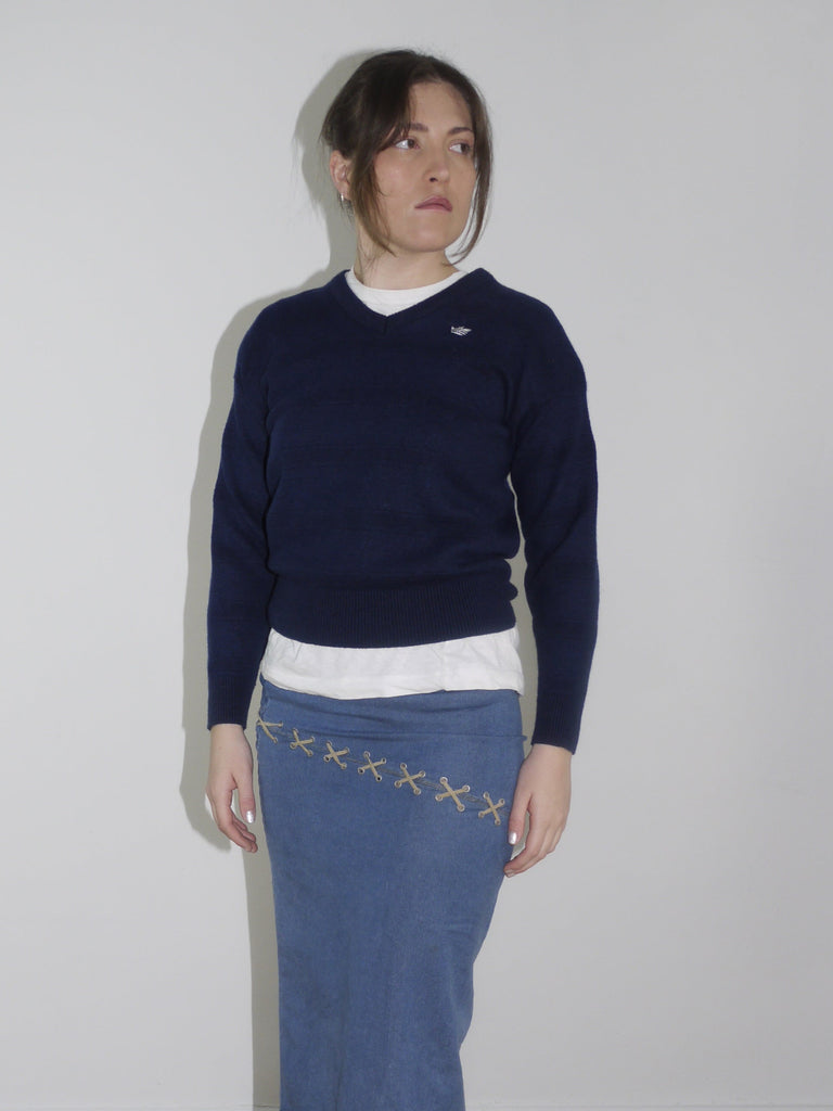 Vintage Adidas navy pullover with white logo stitching on the chest. Classic sportswear look without side stripes, slightly cropped fit, styled with a Y2K-style denim midi skirt.