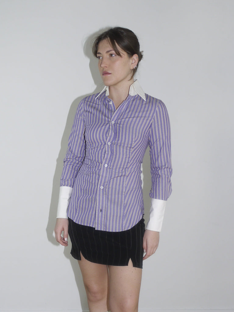 Fitted striped button-up shirt in purple with contrast white cuffs and collar. Sharp silhouette, early 2000s Dsquared vibes. Styled with a pinstripe mini skirt and knee-high boots.