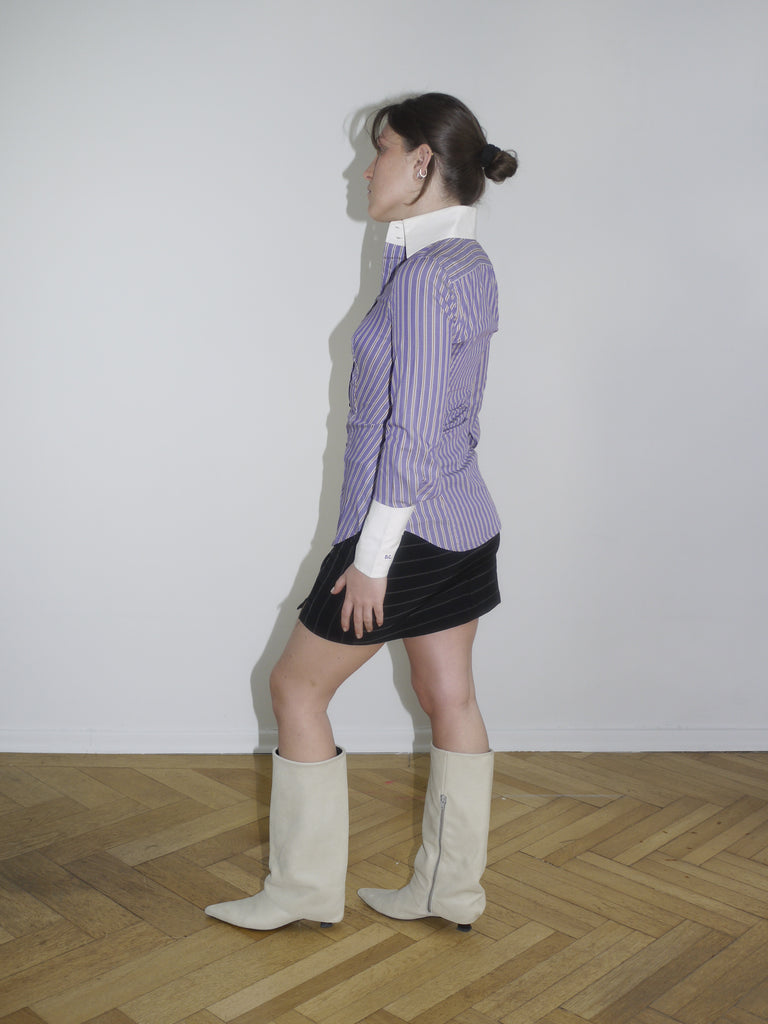 Fitted striped button-up shirt in purple with contrast white cuffs and collar. Sharp silhouette, early 2000s Dsquared vibes. Styled with a pinstripe mini skirt and knee-high boots.