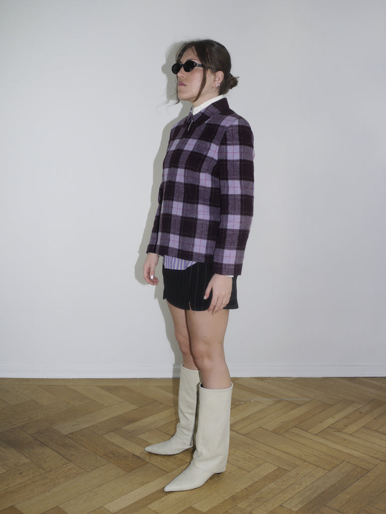 Vintage checked jacket in purple and black tones with structured shoulders, styled over a white-collared shirt and pinstriped mini skirt. Dsquared-inspired layering look for early spring.