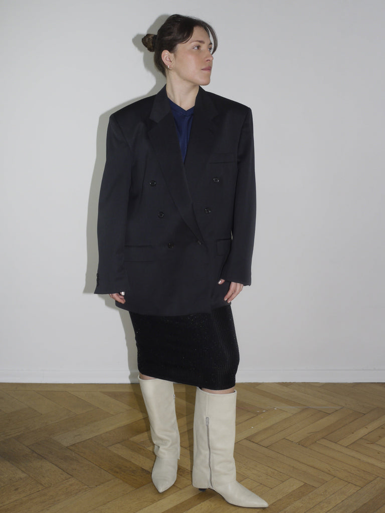 Vintage black oversized blazer with double-breasted buttons and sharp shoulders, styled with a midi pencil skirt and off-white boots. Inspired by Maison Margiela and Dries Van Noten tailoring.