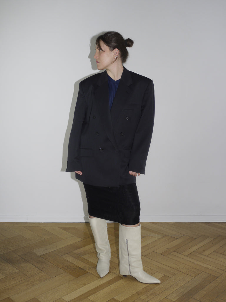Vintage black oversized blazer with double-breasted buttons and sharp shoulders, styled with a midi pencil skirt and off-white boots. Inspired by Maison Margiela and Dries Van Noten tailoring.