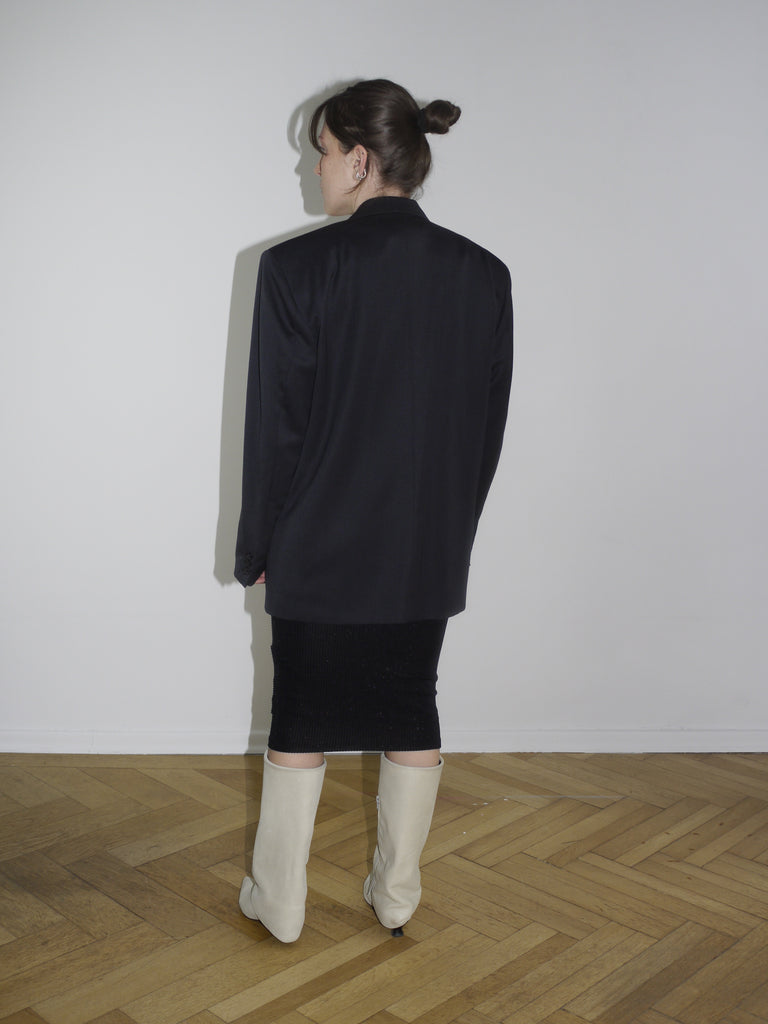 Vintage black oversized blazer with double-breasted buttons and sharp shoulders, styled with a midi pencil skirt and off-white boots. Inspired by Maison Margiela and Dries Van Noten tailoring.