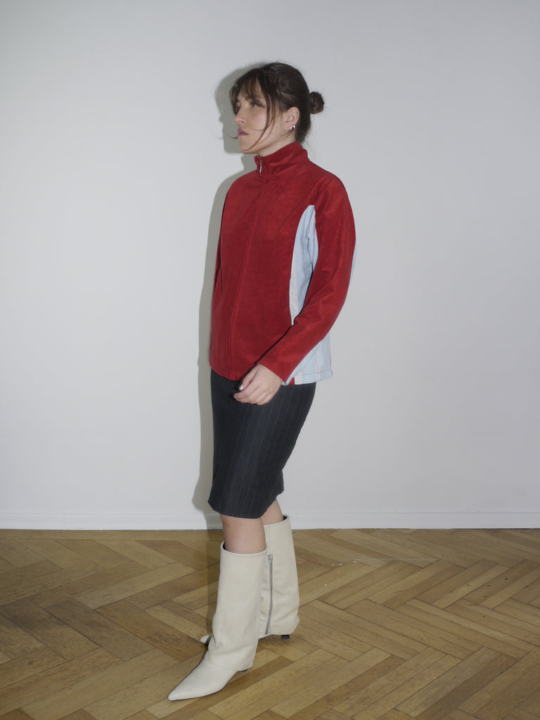 Vintage red zip-up fleece jacket with white contrast panels – retro sporty look inspired by early 2000s streetwear, similar to pieces by Diesel and Lotto.