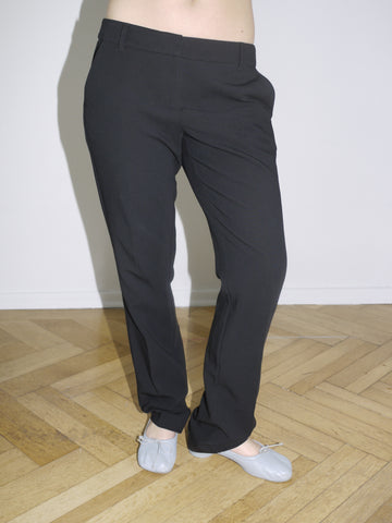 Close-up of black low-rise pants with contrast stripe – inspired by early 2000s Diesel tailoring.