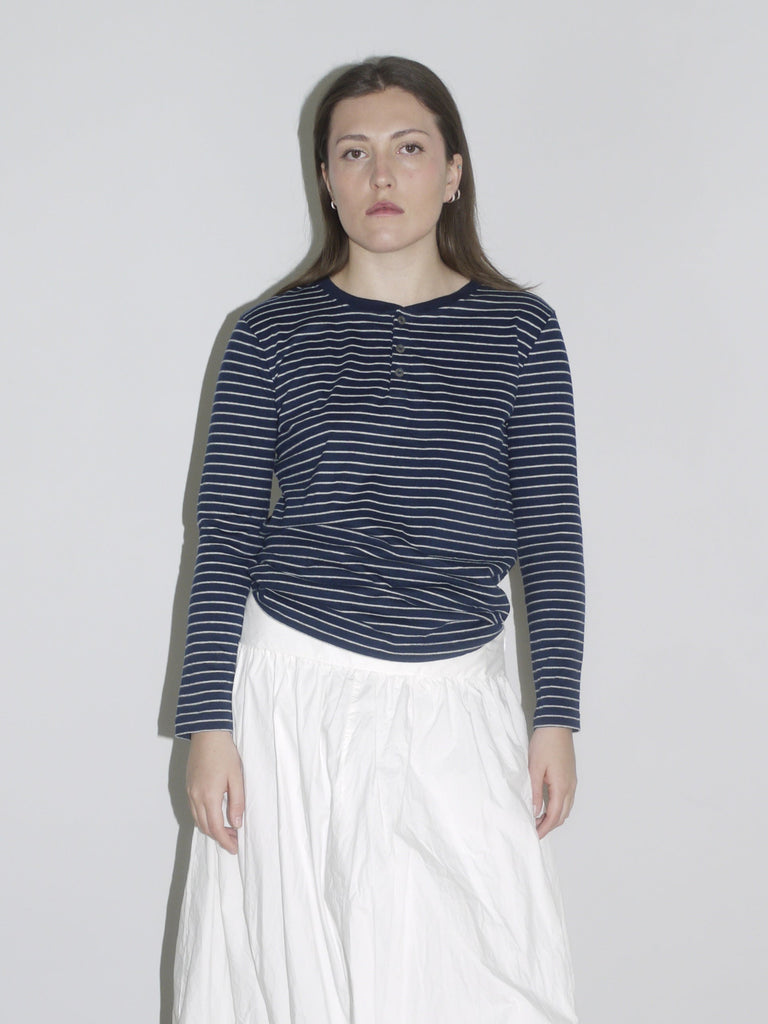 Navy striped long sleeve styled with a voluminous white skirt and slouch boots — minimalist vintage meets Margiela schoolgirl aesthetic.