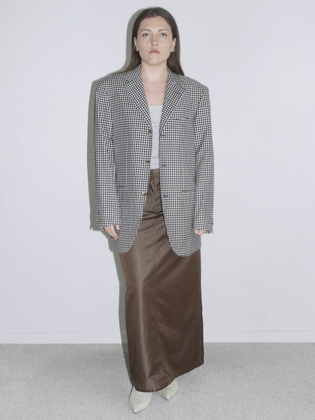 Model wearing an oversized checkered blazer paired with wide brown trousers – bold look with bright orange lipstick and pink faux fur detail, inspired by Maison Margiela and 90s editorials.