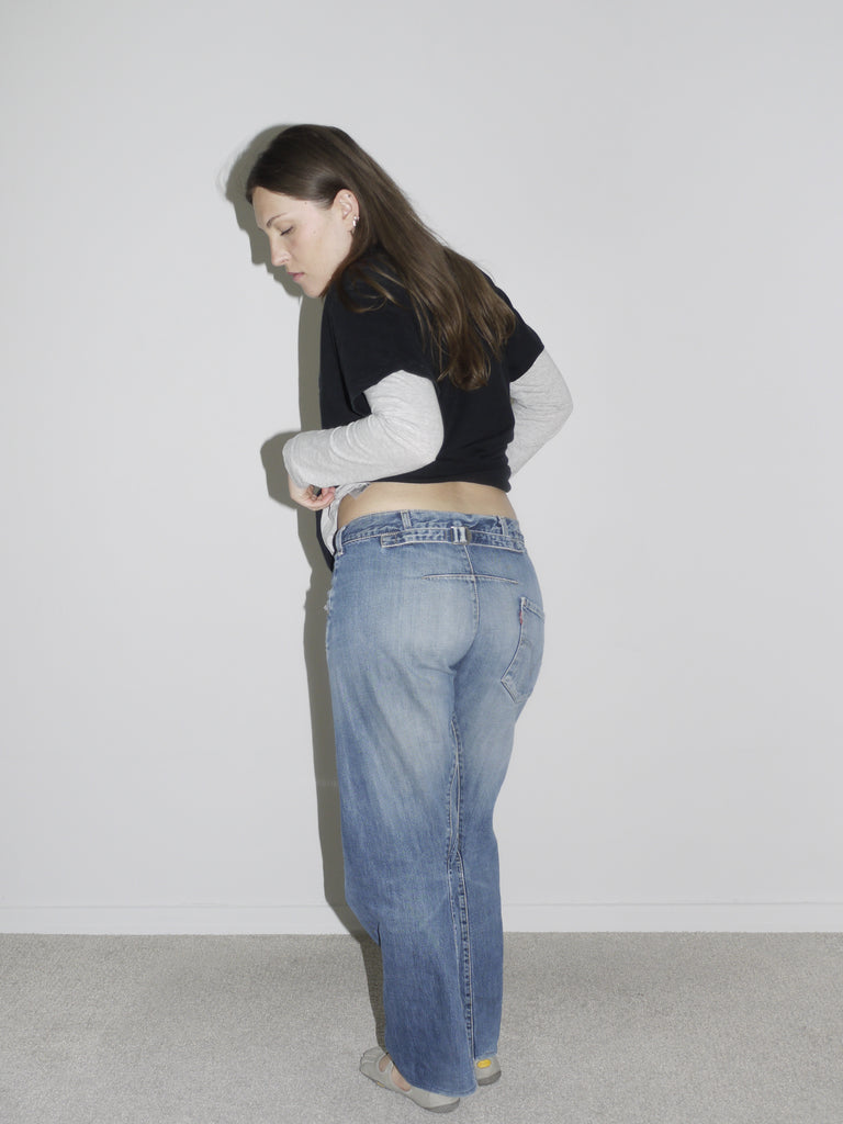Model turned away from camera, wearing vintage Levi’s Engineered Jeans with asymmetrical back yoke and twisted seams, styled with layered long-sleeve and cropped black tee. A signature early 2000s denim silhouette — iconic, deconstructed, and pure Levi’s archive energy.