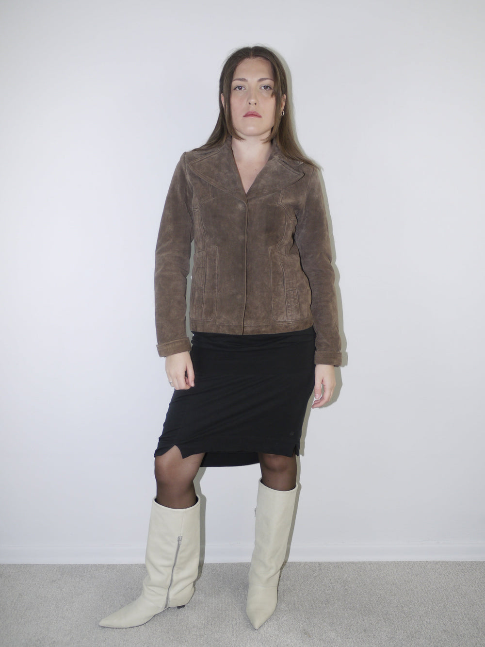 Model wearing a cropped brown faux fur jacket over a soft white vintage-style dress and black leather boots – Miu Miu inspired layered look with retro femininity.