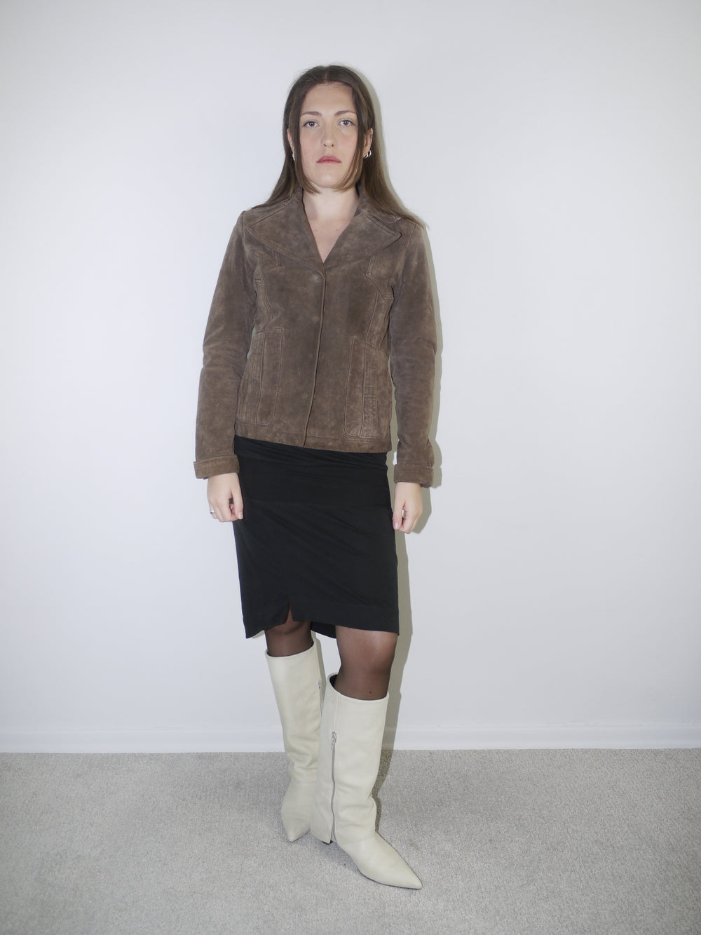 Model wearing a cropped brown faux fur jacket over a soft white vintage-style dress and black leather boots – Miu Miu inspired layered look with retro femininity.