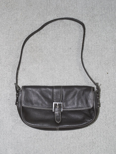 Vintage black leather shoulder bag with structured silhouette, silver buckle detail on the front flap, and contrast white stitching, evoking a classic early 2000s aesthetic.