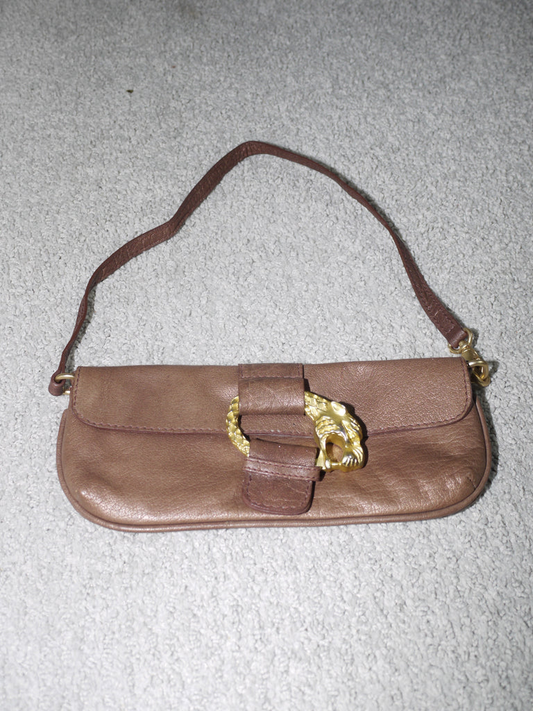 Vintage baguette bag in soft brown leather with a gold lion-head buckle detail. Features a curved rectangular silhouette and single shoulder strap—statement accessory with Y2K flair.