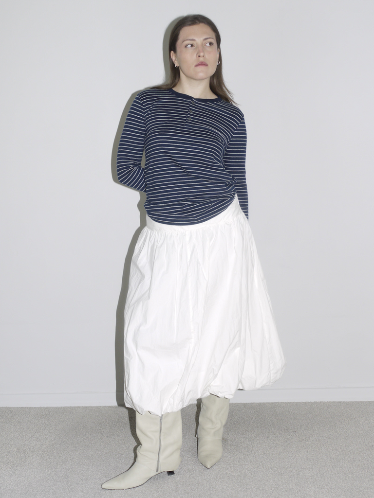 Navy striped long sleeve styled with a voluminous white skirt and slouch boots — minimalist vintage meets Margiela schoolgirl aesthetic.