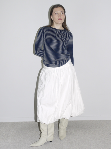Navy striped long sleeve styled with a voluminous white skirt and slouch boots — minimalist vintage meets Margiela schoolgirl aesthetic.