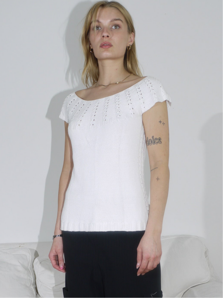 Model in a white eyelet knit top paired with structured black culottes. A clean monochrome look with playful texture and relaxed tailoring.