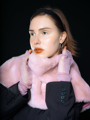 Model wearing a cropped black houndstooth blazer paired with a fluffy baby pink faux fur stole – a glam, archive-inspired statement look with playful contrast, reminiscent of early 2000s runway.