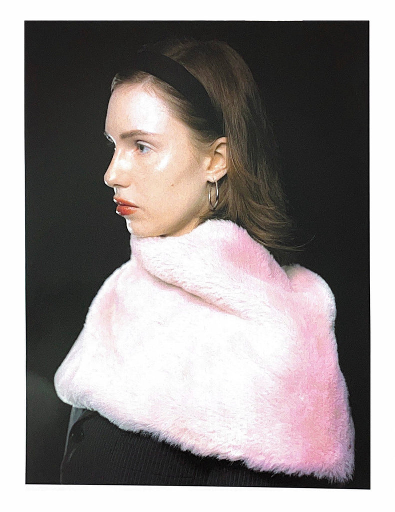 Model wearing a cropped black houndstooth blazer paired with a fluffy baby pink faux fur stole – a glam, archive-inspired statement look with playful contrast, reminiscent of early 2000s runway.