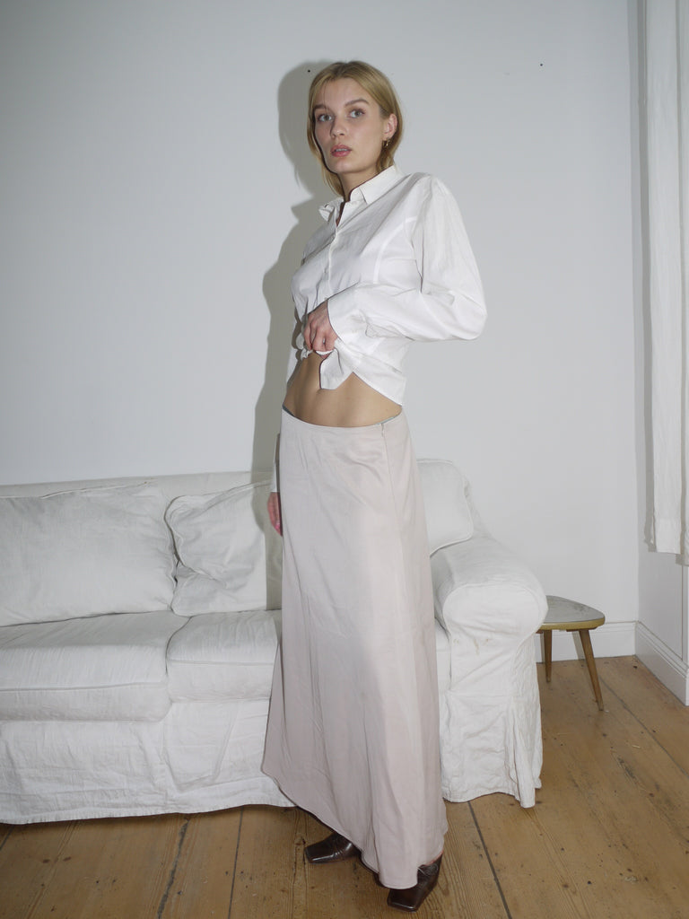 Model wearing a white G-Star button-up shirt with a structured fit and classic collar, paired with a beige skirt. Clean lines and subtle branding give it a sharp, minimal look.