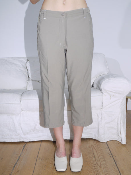 Cropped khaki trousers with subtle pleat detailing and a relaxed fit, paired with off-white square-toe heels. A clean and minimal everyday look.
