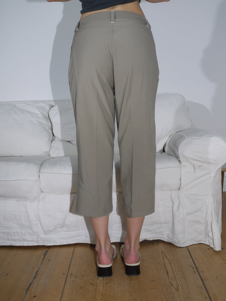 Cropped khaki trousers with subtle pleat detailing and a relaxed fit, paired with off-white square-toe heels. A clean and minimal everyday look.